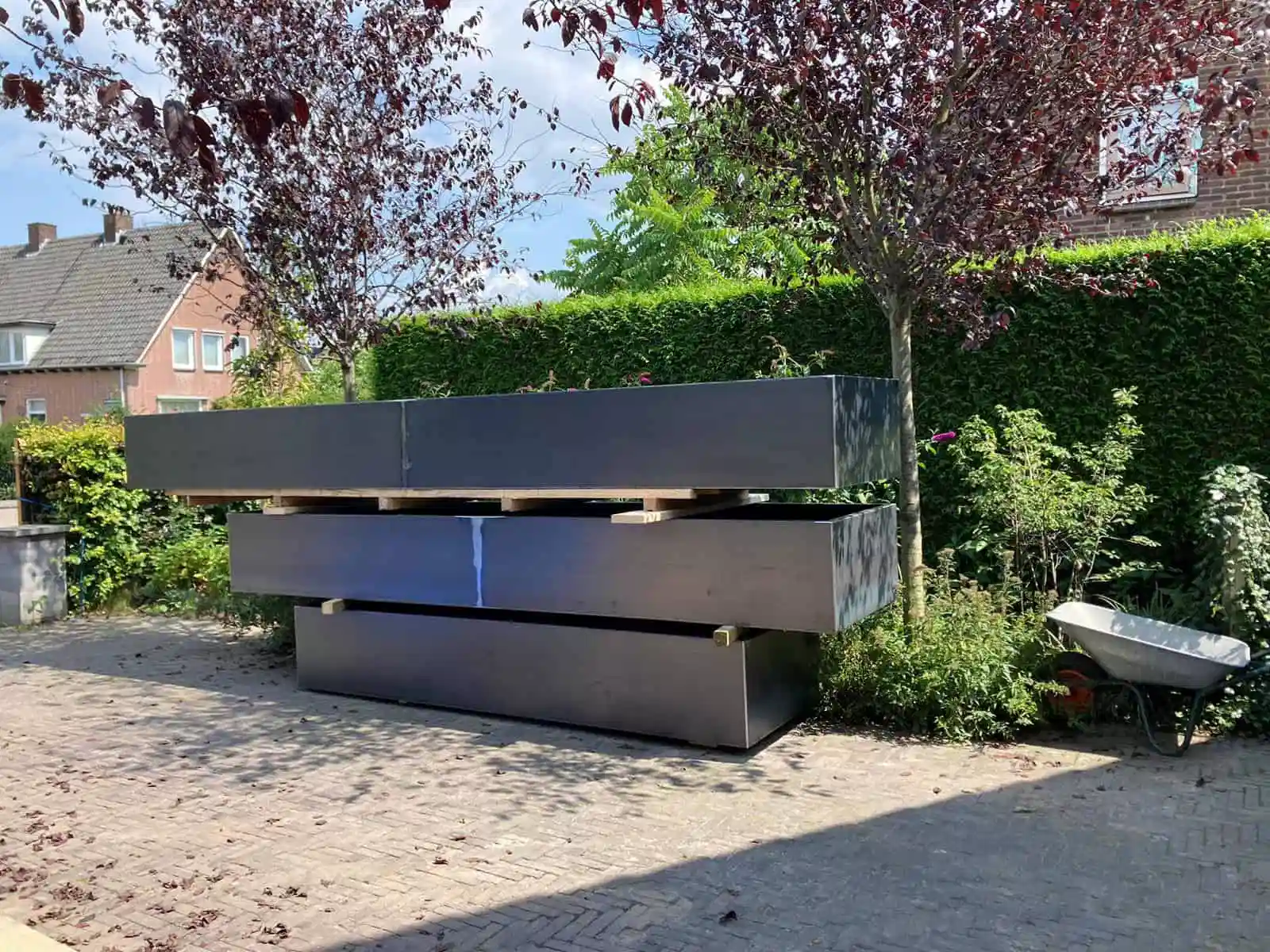 Aanleg van nieuwe paden bij een groot houten tuinhuis