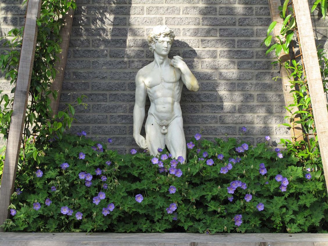 stads-tuinontwerp trapezium in nijmegen van het buitenland met close up van het apollobeeld in een geraniumveldje in het prieel