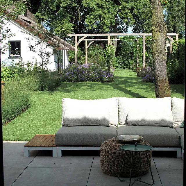 landschaps-tuinontwerp eten uit je tuin in nijmegen van het buitenland met een loungebank met in de verte een tuinkamer