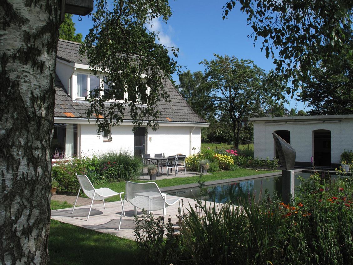 landschaps-tuinontwerp ommeland in nijmegen van het buitenland met een zwemvijver omsloten door woning en terrasoverkapping