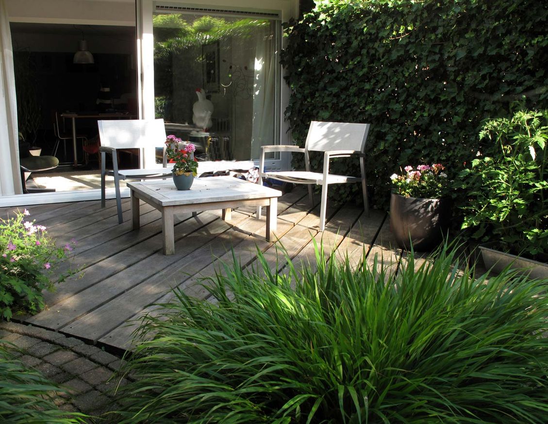 stads-tuinontwerp bergstroom in nijmegen van het buitenland met loungeterras van diagonaal gelegde planken met witte lounge set