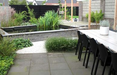 stads-tuinontwerp koi tuin in nijmegen van het buitenland met eetterras grenzend aan de verhoogde natuurstenen koi vijver