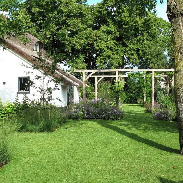 landschaps-tuinontwerp eten uit je tuin in nijmegen van het buitenland met een zichtas onder een boom door naar 2 pergola's