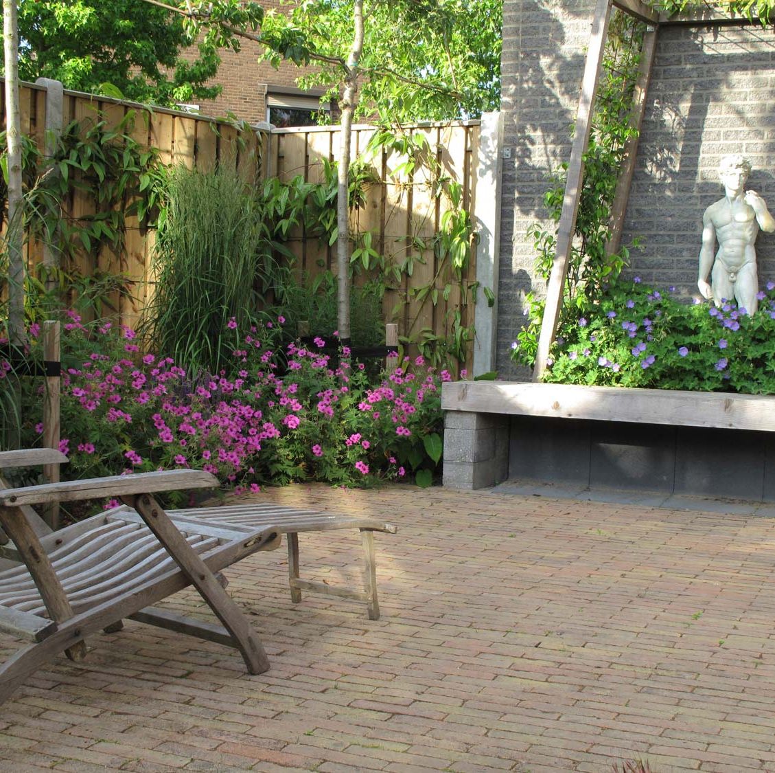 stads-tuinontwerp trapezium in nijmegen van het buitenland met ligstoel op trapeziumvormig terras uitkijkend op het prieel