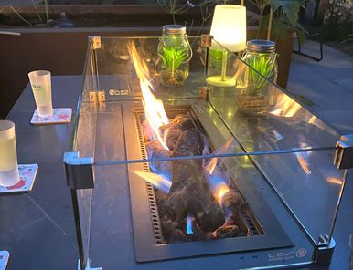 stads-tuinontwerp stads oase in nijmegen van het buitenland met een close up van een verlichte vuurtafel 