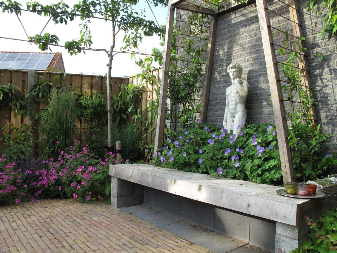stads-tuinontwerp trapezium in nijmegen van het buitenland met trapeziumvormig prieel met bankje en apollobeeld in geraniums