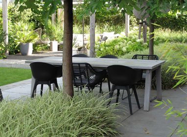stads-tuinontwerp tuin in terrassen in nijmegen van het buitenland met close up van eettafel tussen 2 vakken wit bonte grassen
