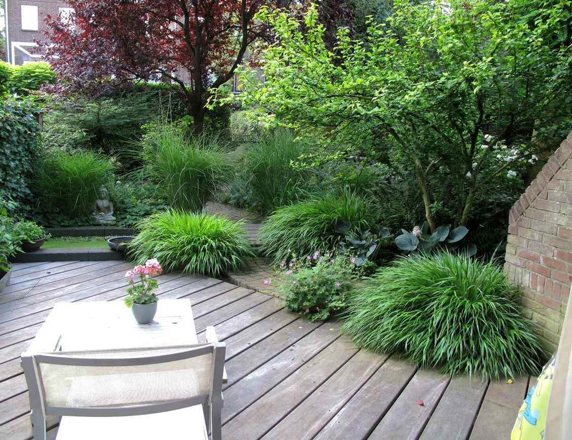 stads-tuinontwerp bergstroom in nijmegen van het buitenland met loungeterras met diagonale planken leidend naar pad met grassen