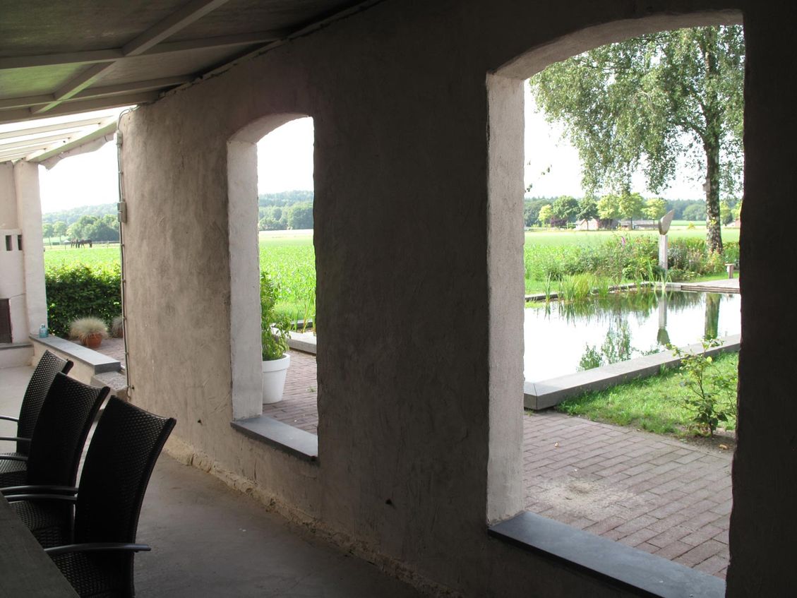 landschaps-tuinontwerp ommeland in nijmegen van het buitenland met doorkijkjes op de zwemvijver vanuit de terrasoverkapping