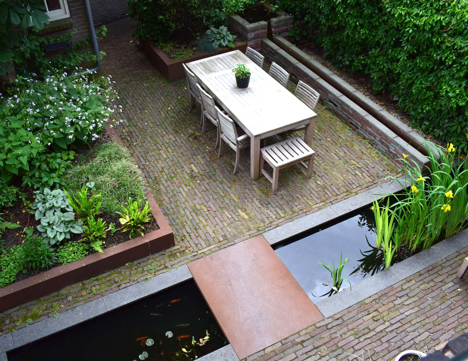 stads-tuinontwerp levensloop in nijmegen van het buitenland met vogelvluchtfoto van de achtertuin met eetterrras en strakke vijver