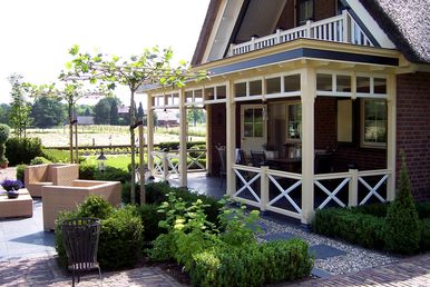 landschaps-tuinontwerp tuin in vorm in nijmegen van het buitenland met een klassieke engelse veranda voor het huis