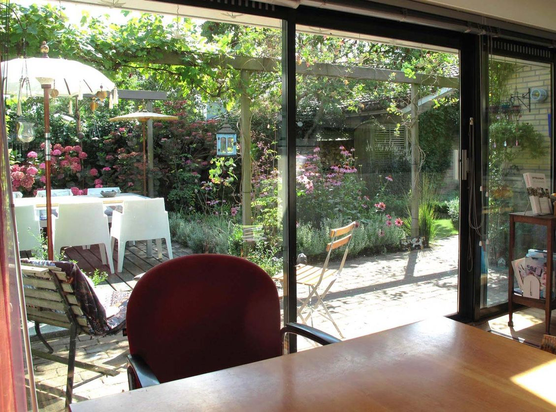 stads-tuinontwerp mozaiek in nijmegen van he buitenland met zicht door glazen pui van keuken op achtertuin